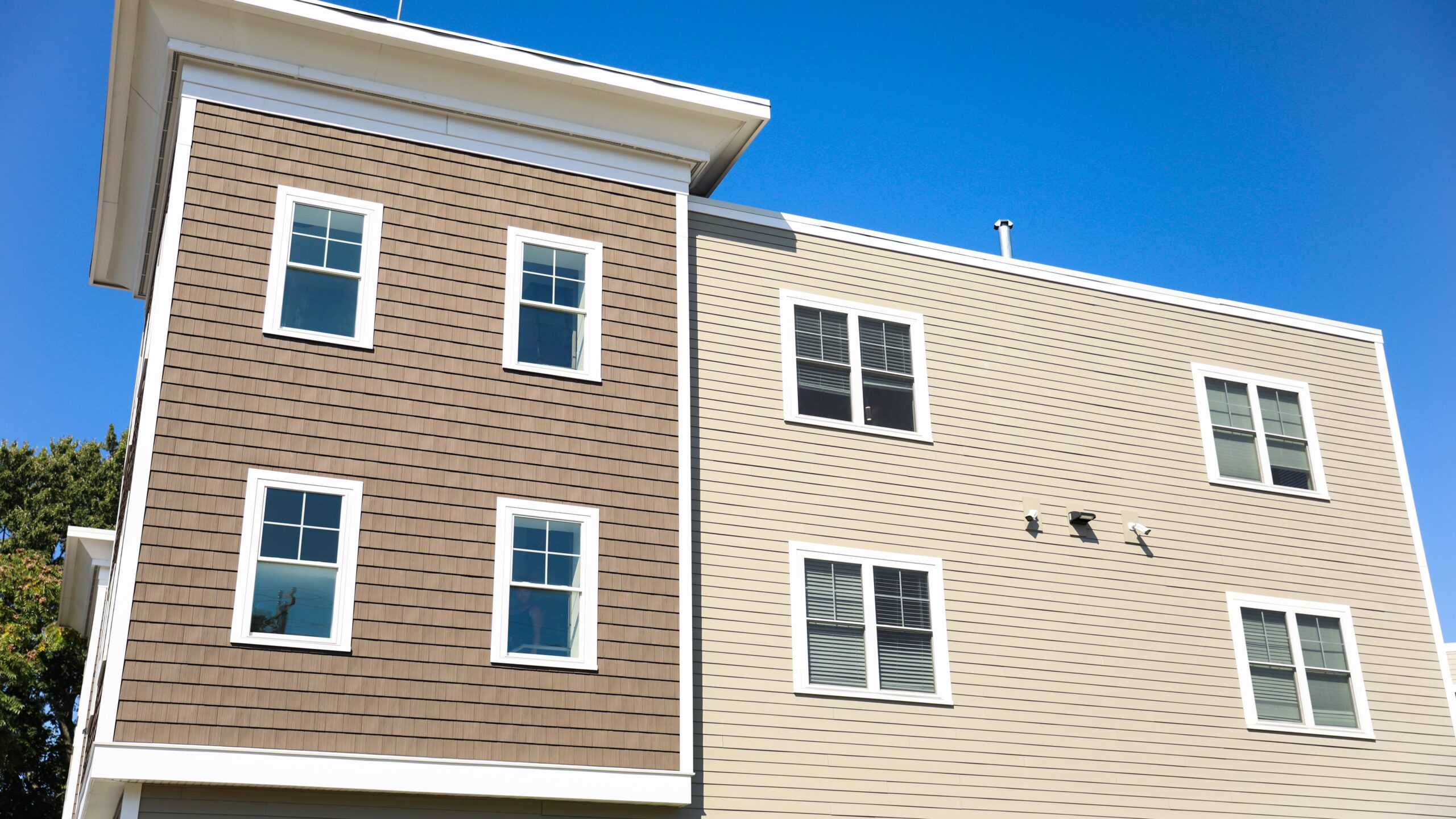 Home exterior with two different shades of brown siding and four windows on each side