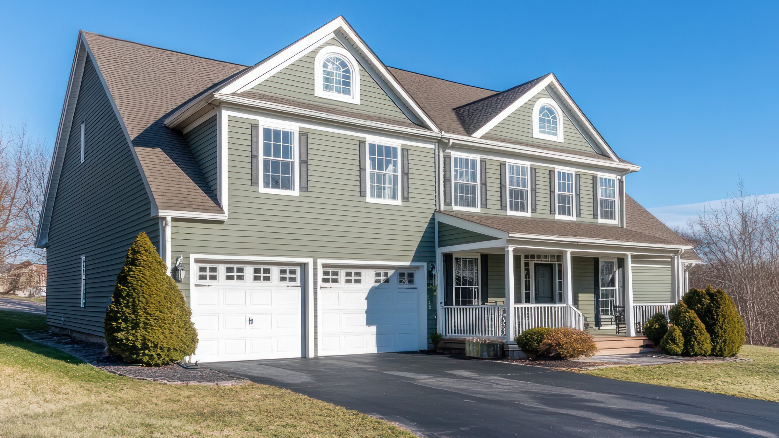 Home exterior with cream-colored siding and beautiful metal roof with a for sale sign out front