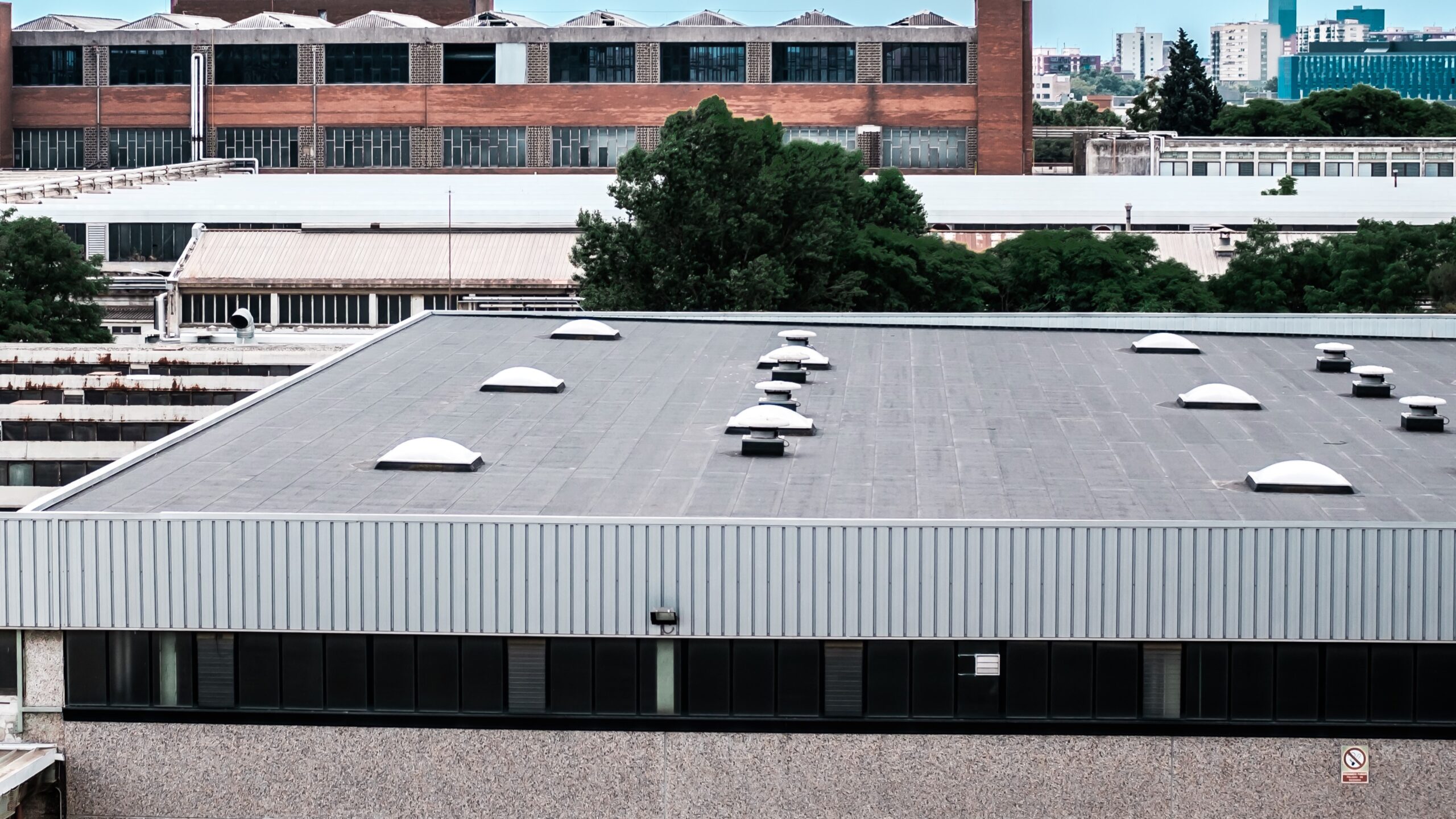 Flat commercial roof outlooking large industrial area with lots of buildings