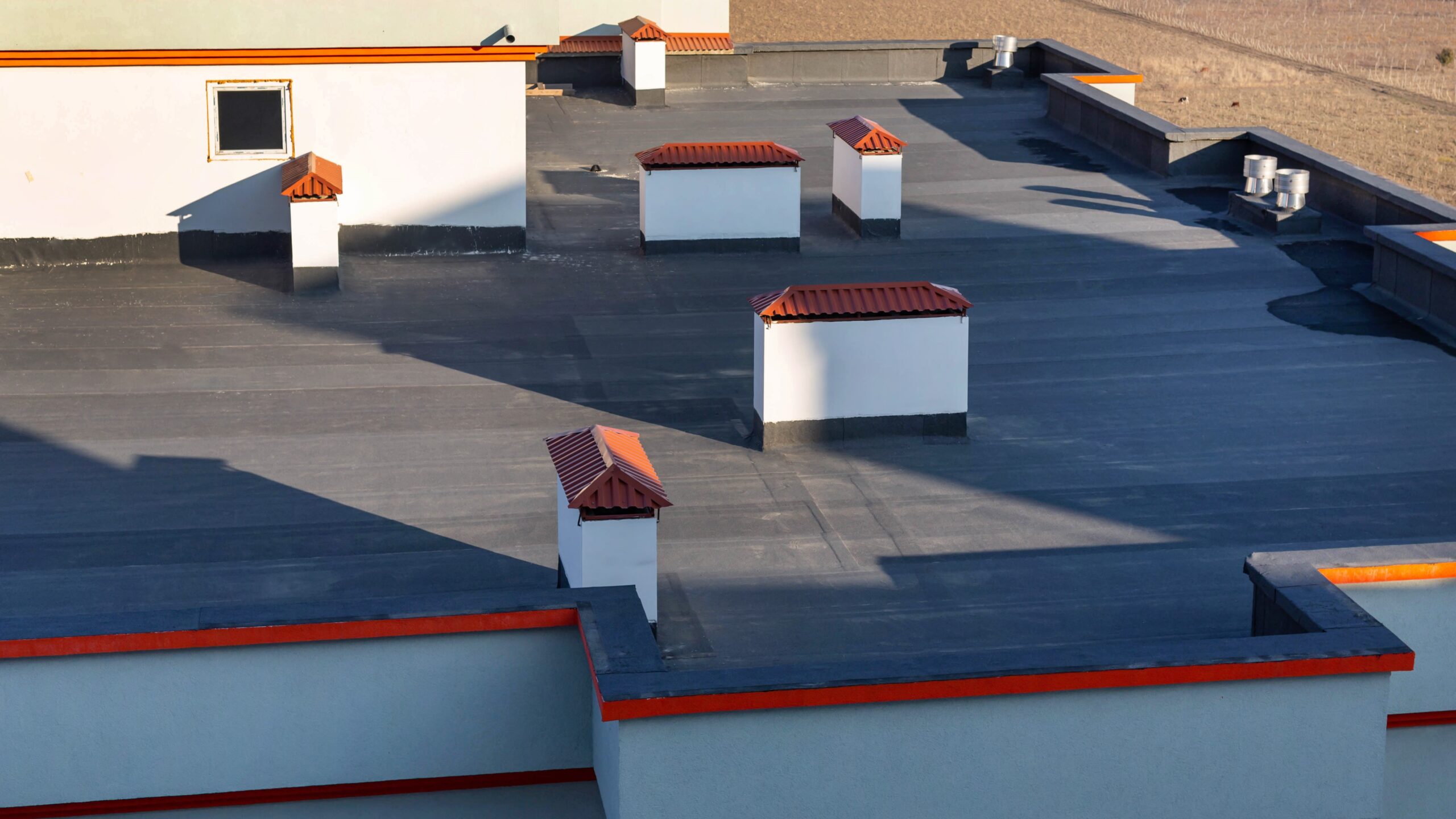Top of commercial building with flat dark roof