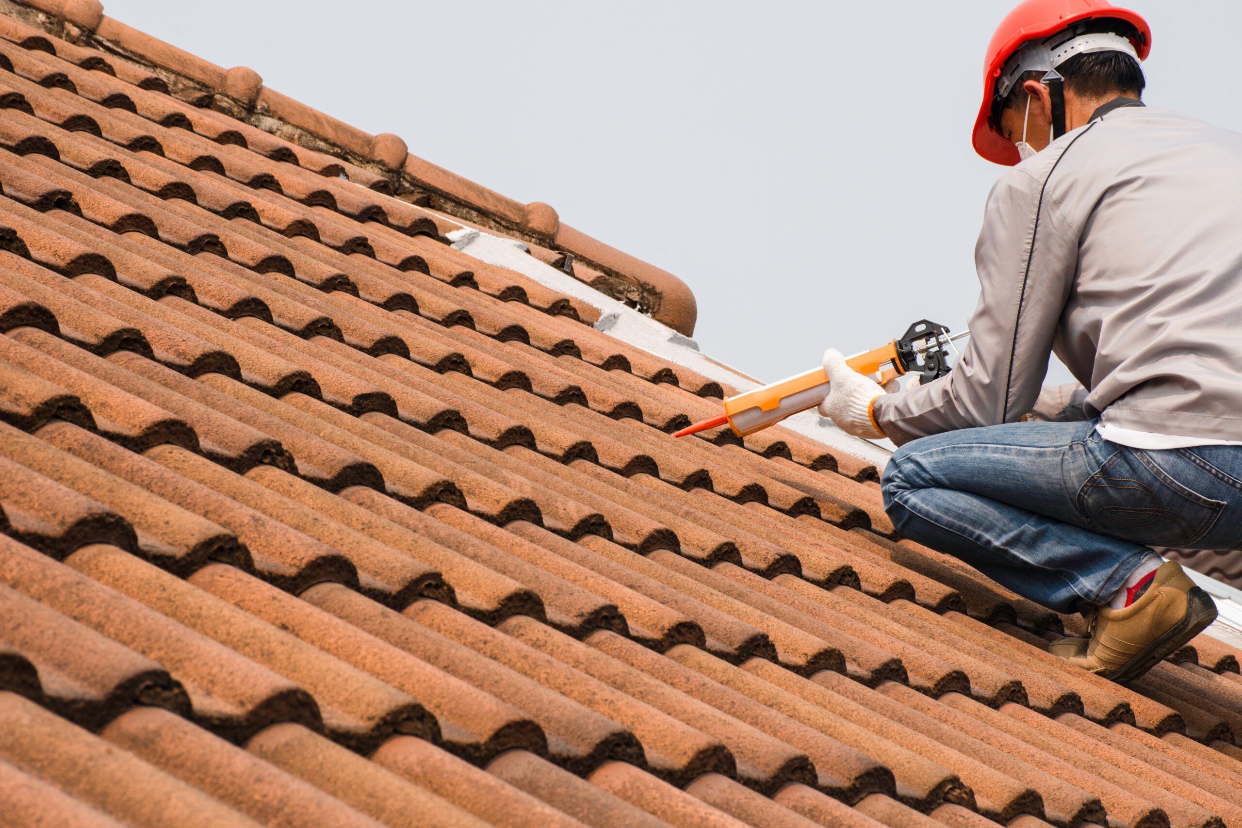Roofer repairing a tile roof