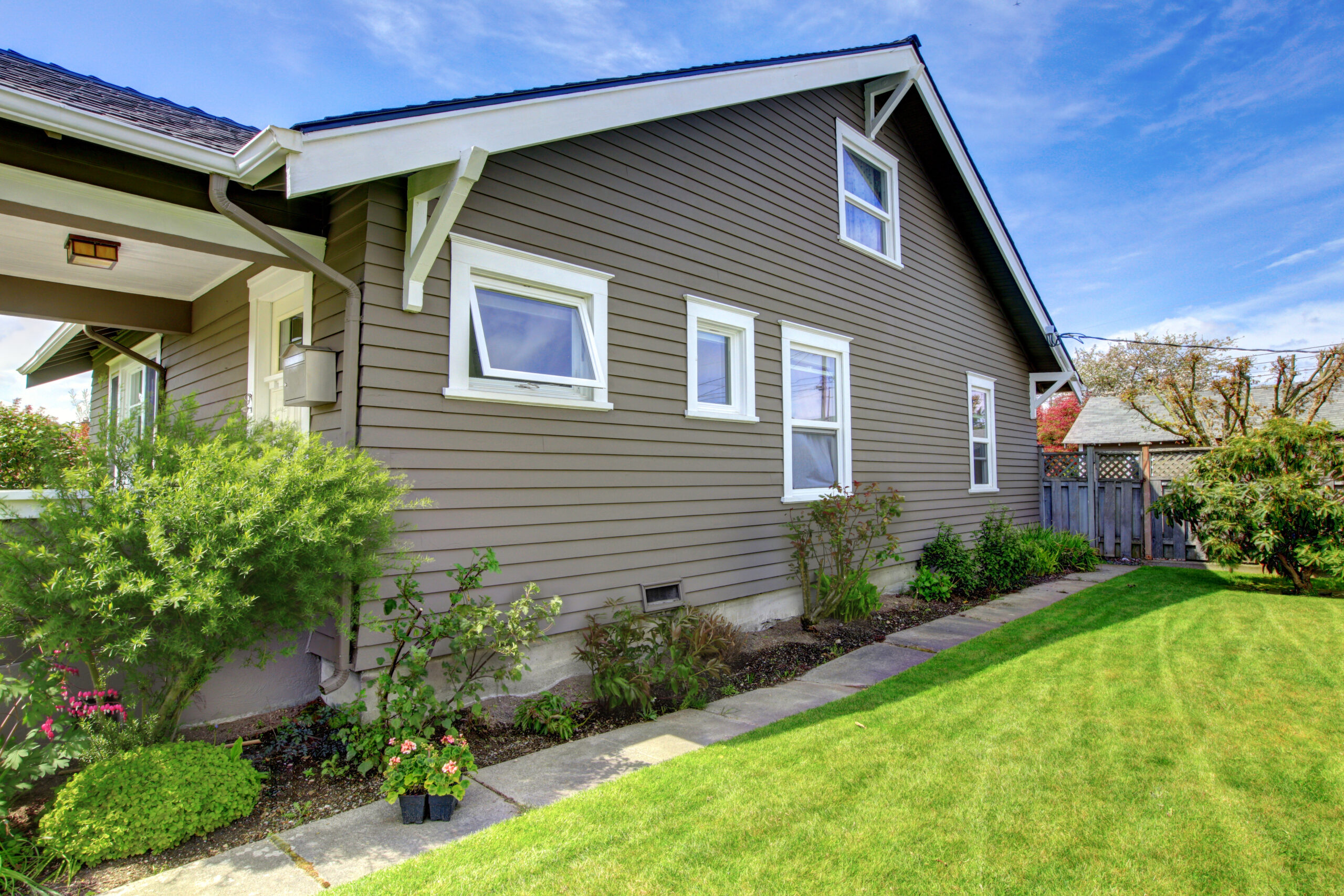 Side of a house with gray siding and windows