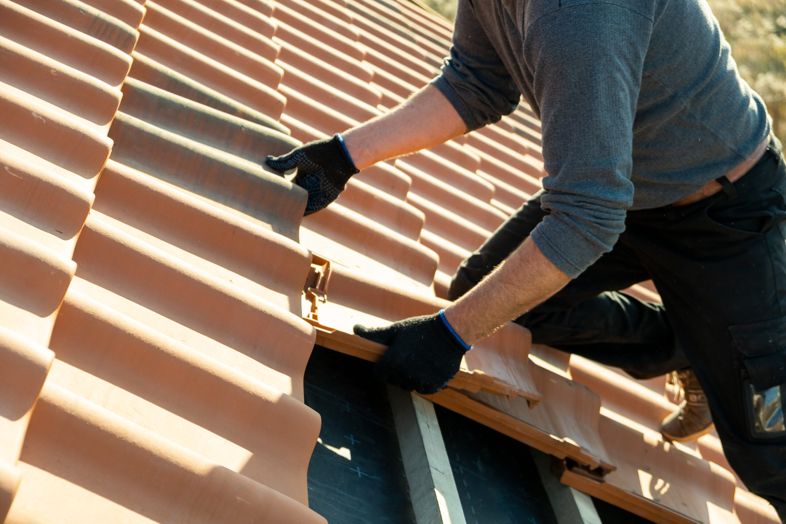 Roofer installing tiles on a new roof