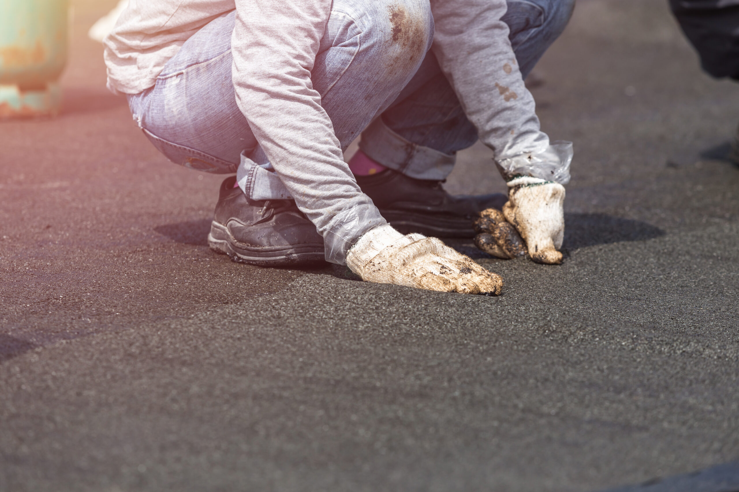 Roofer performing maintenance tasks on a flat commercial roof