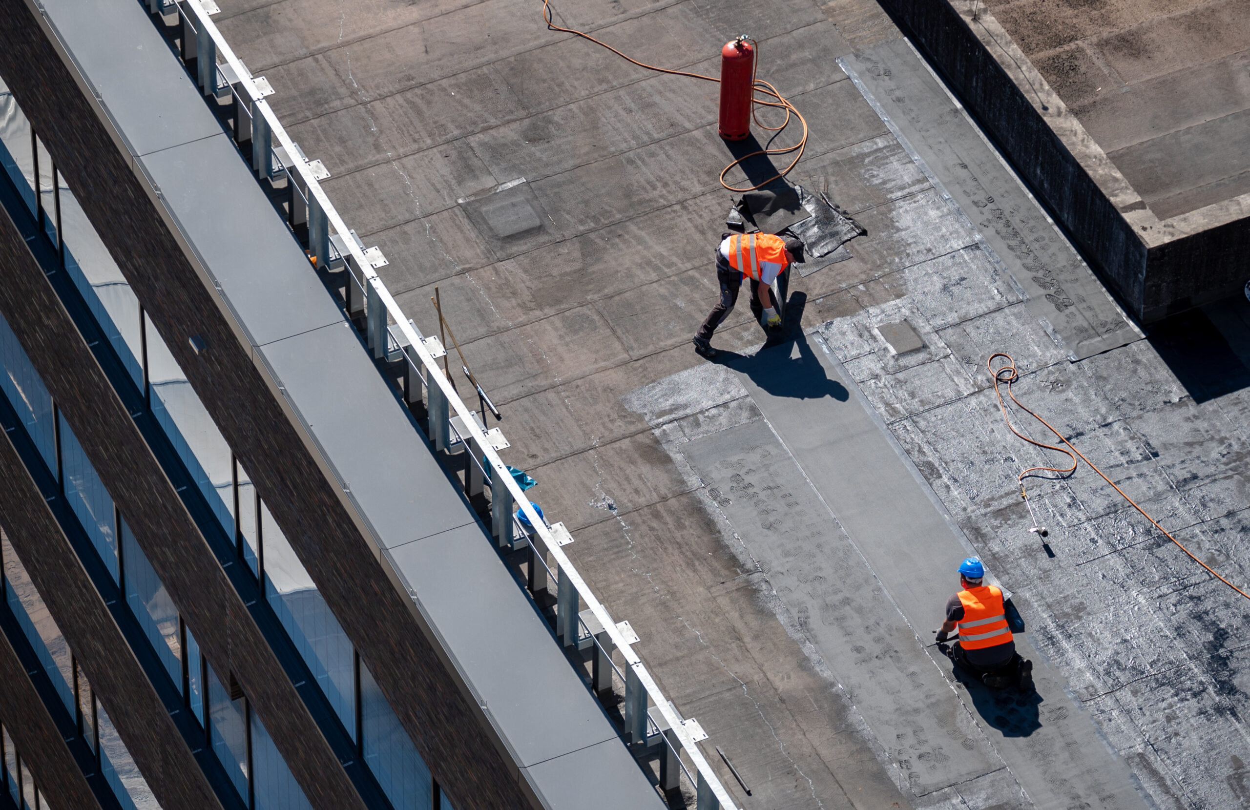 Roofers performing maintenance on a flat roof