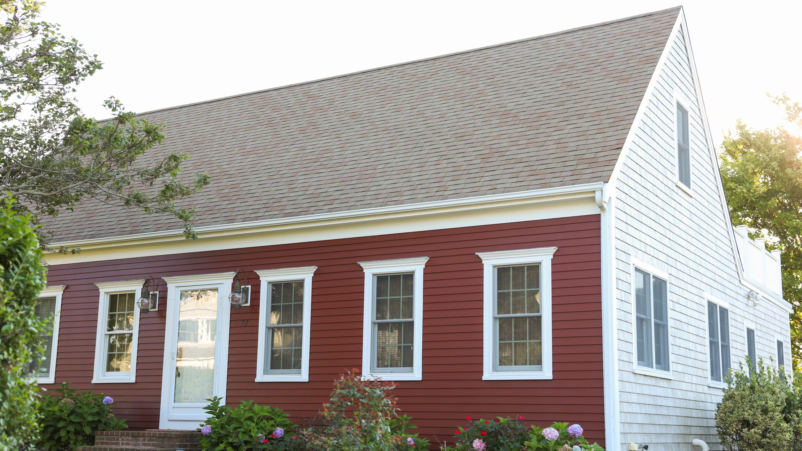 Home with large steep-sloped asphalt roof and beautiful red siding