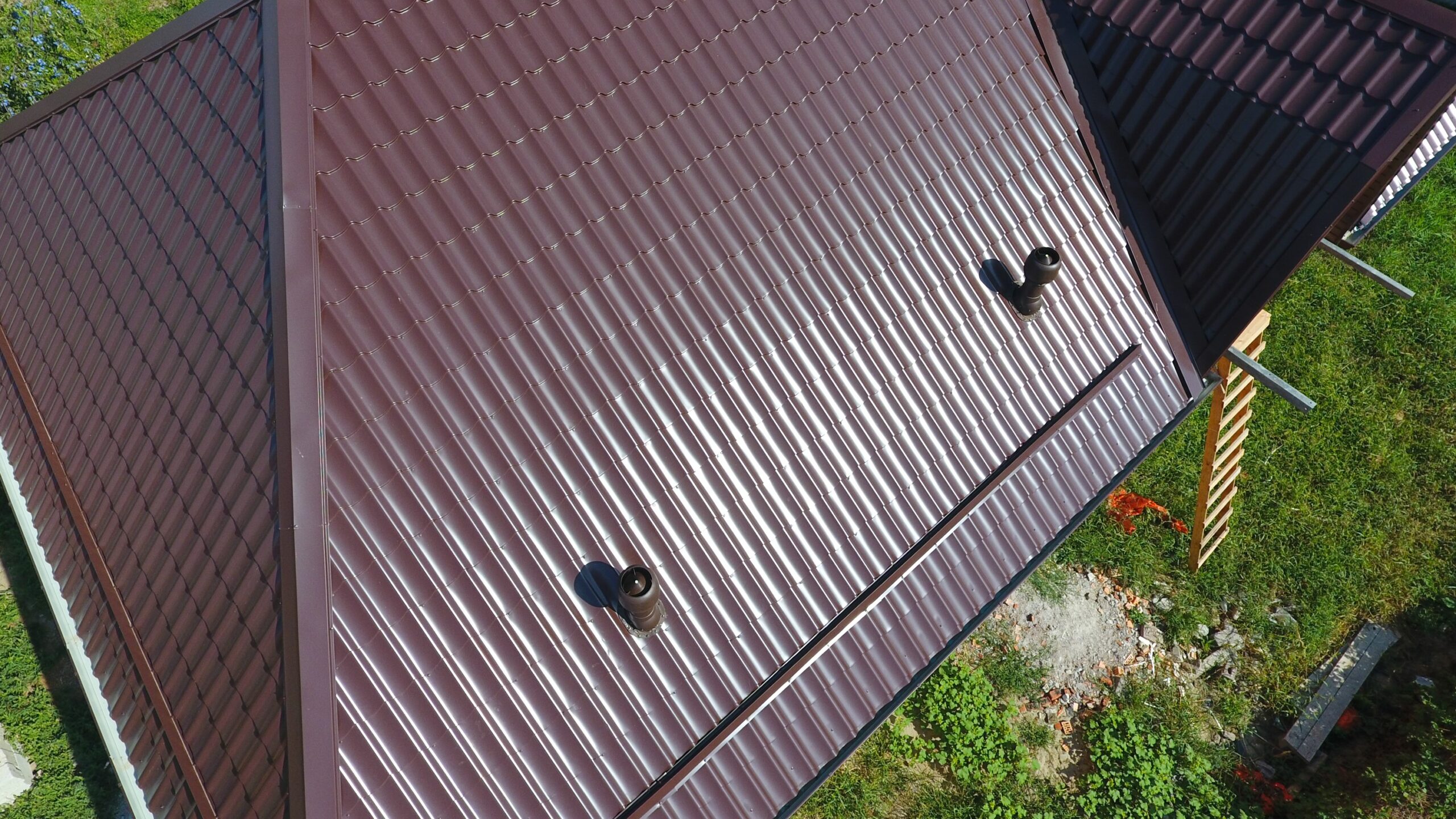 Aerial view of home with burgundy metal roof