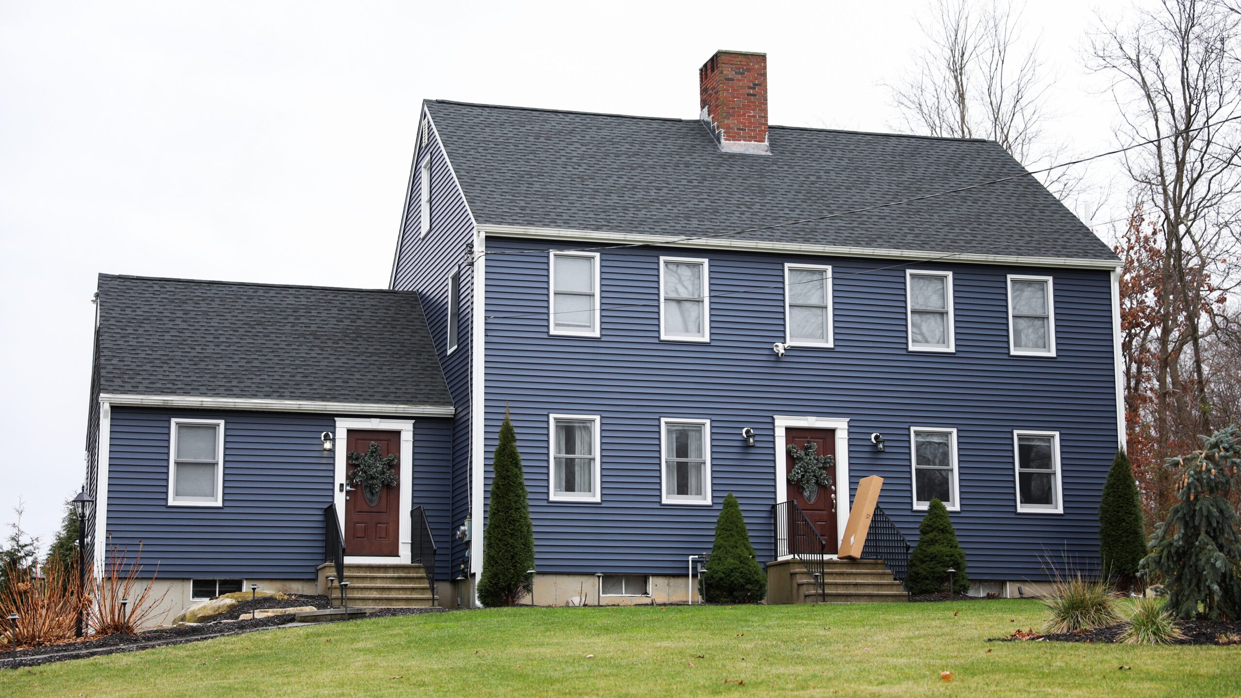 Home with dark blue siding and dark asphalt shingle roof