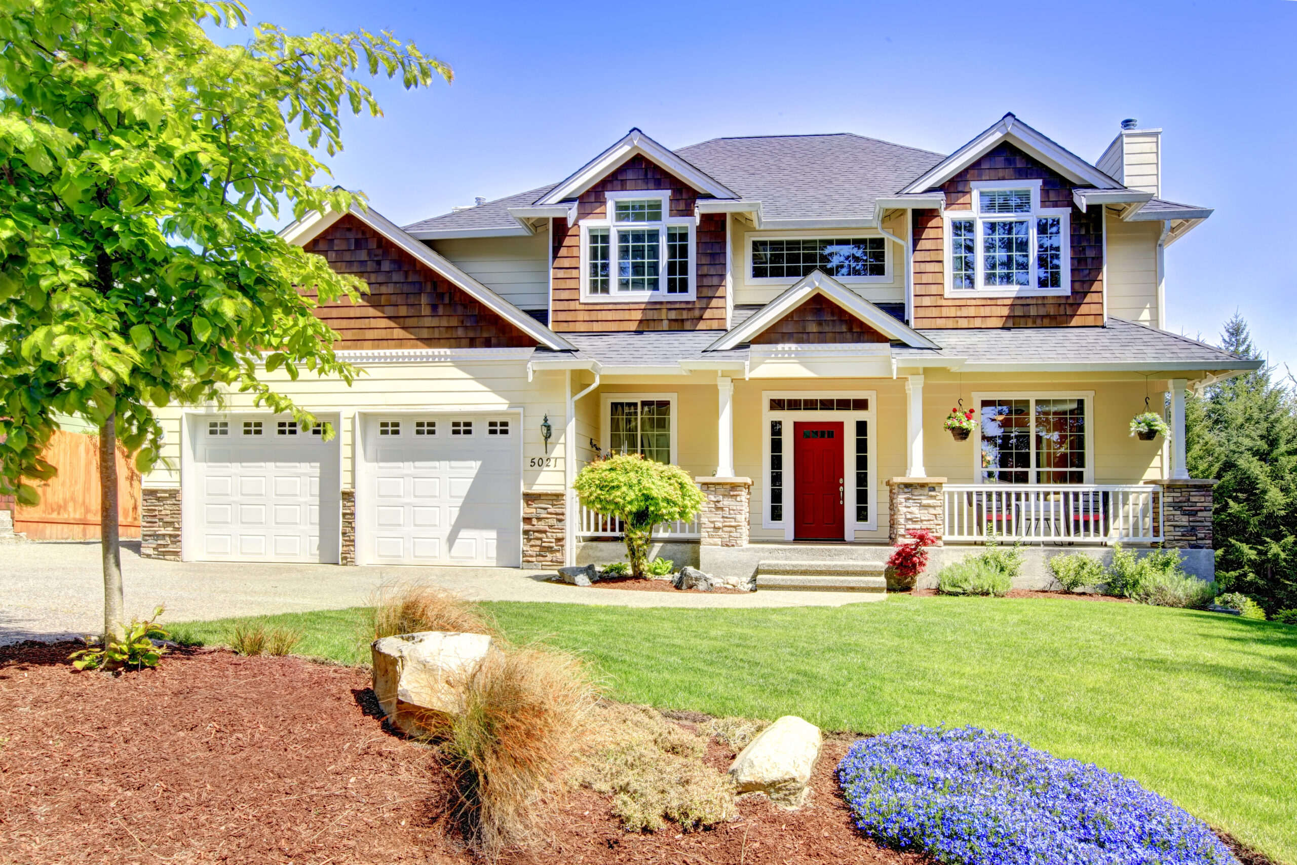 Two-story house with yellow siding and a red door