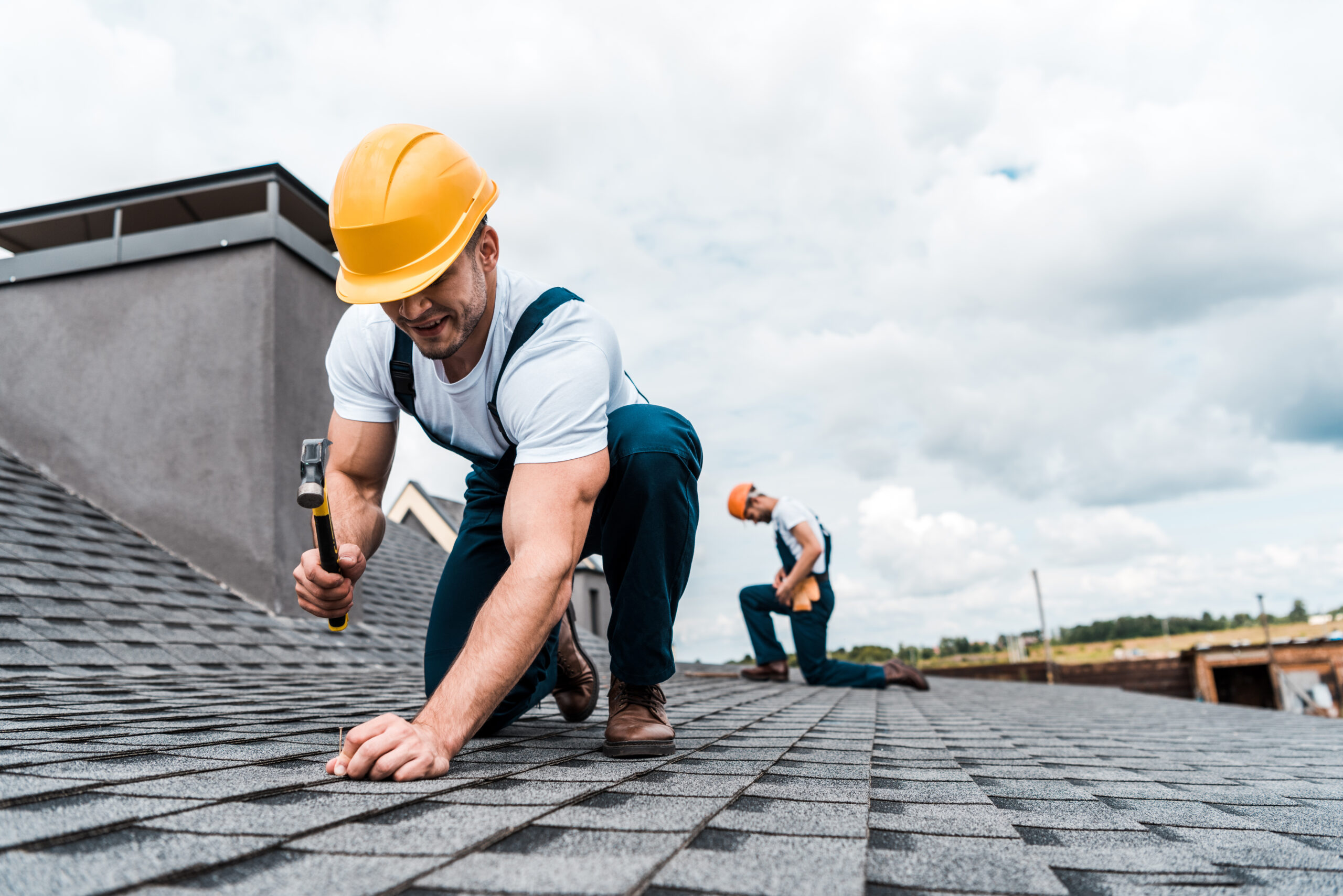 Roofers repairing a shingle roof