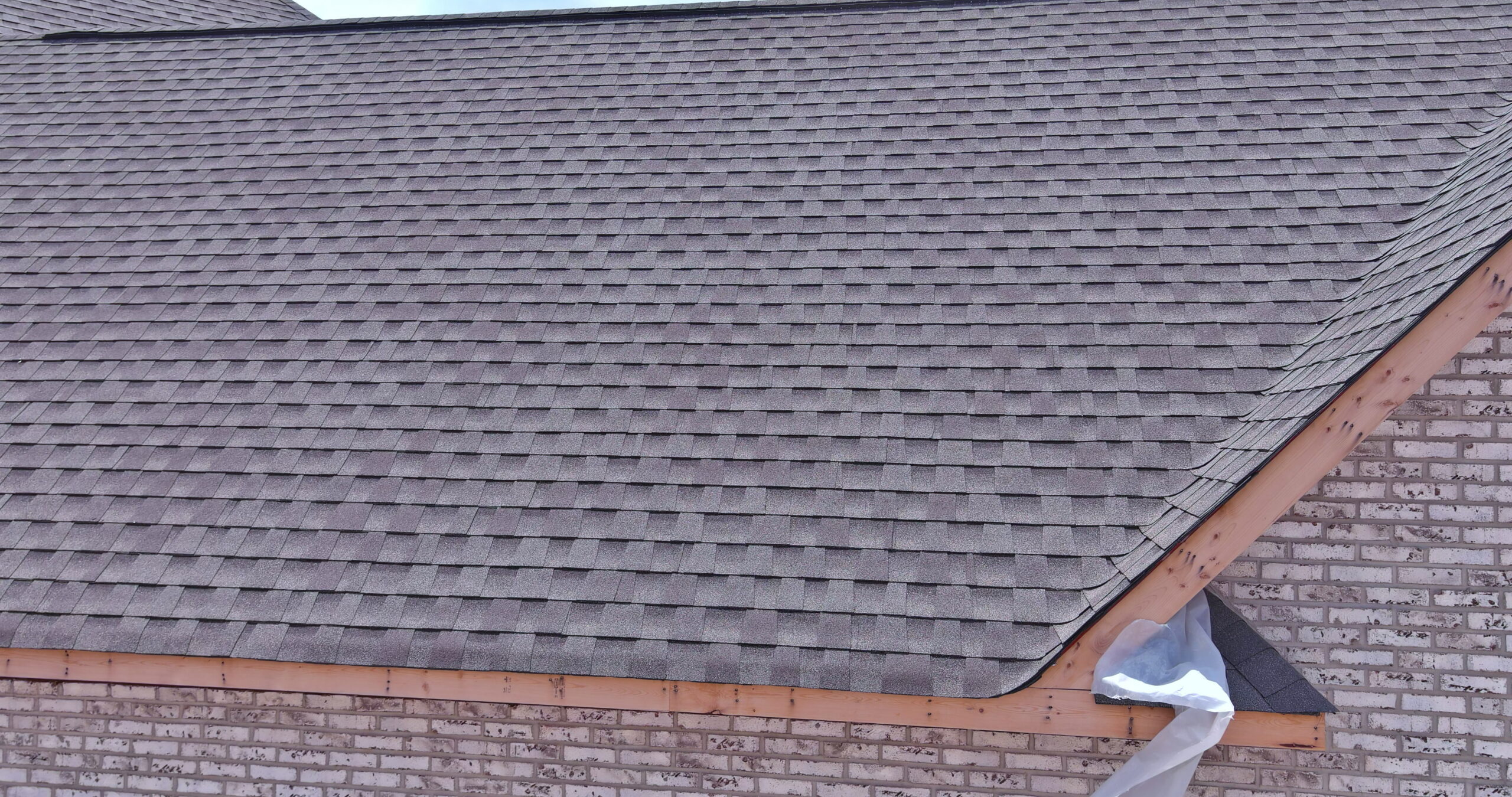 New reddish-brown asphalt shingles on a residential building in Eastern Oklahoma.